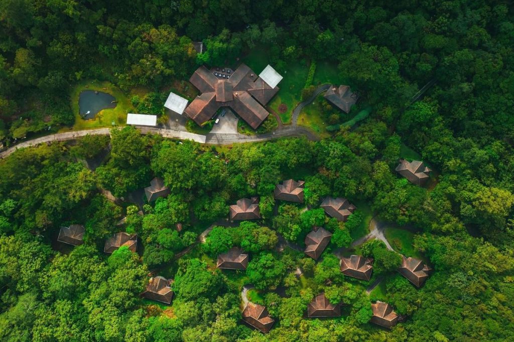 Wide aerial view of El Silencio Lodge & Spa property, showing luxury villas scattered across the lush Bajos del Toro valley.