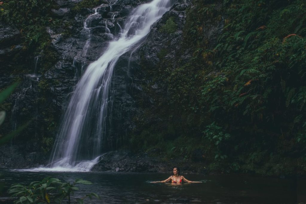 A guest enjoying a natural waterfall pool at El Silencio Lodge & Spa, showcasing immersive nature experiences.