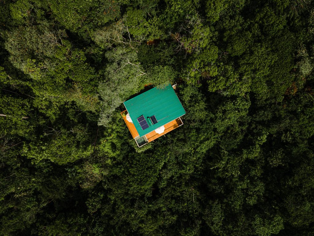Aerial view of sustainable wooden cabins at El Remanso Lodge tucked into the misty Osa Peninsula forest.