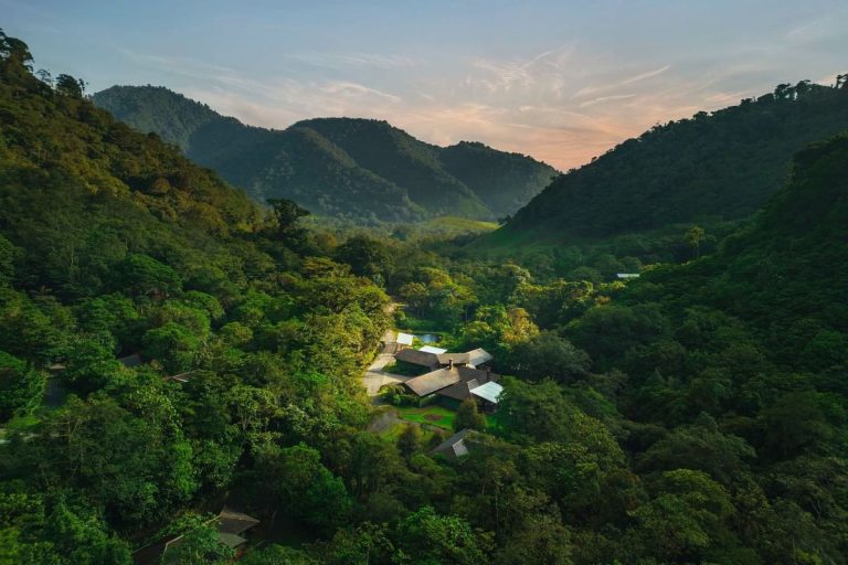 Distant aerial view of El Silencio Lodge nestled in the mist of the Costa Rican cloud forest at sunset.