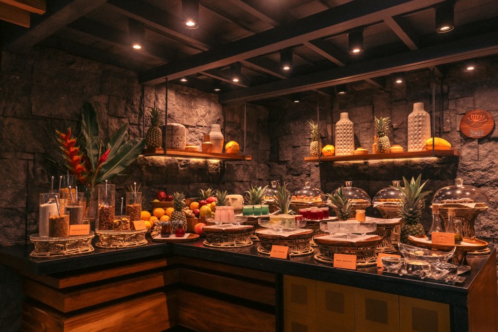Gourmet breakfast buffet and regional cuisine display at Awā Beachfront Hotel's rustic stone restaurant.